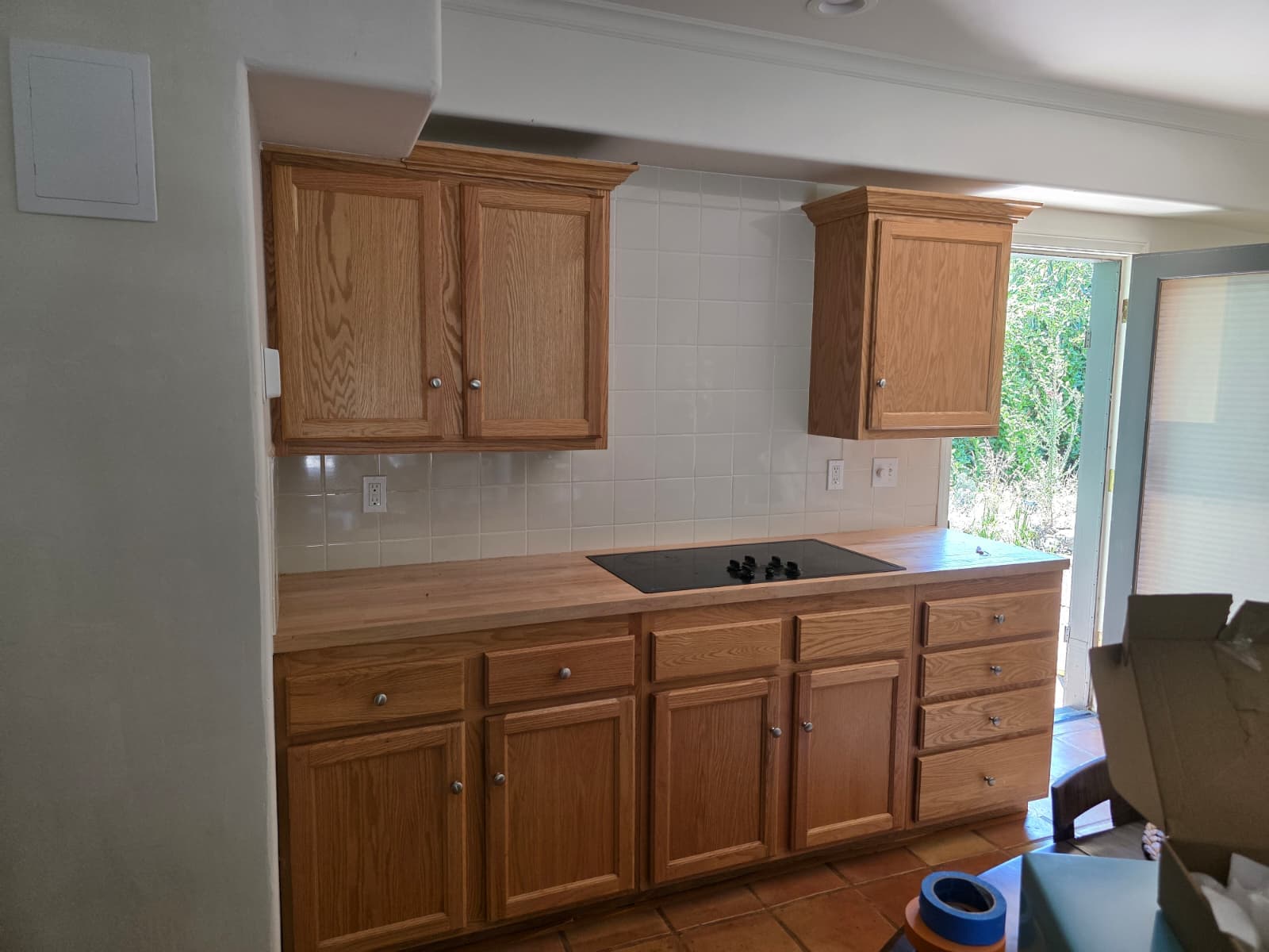 Kitchen cabinets before refinishing with warm wood cabinet fronts