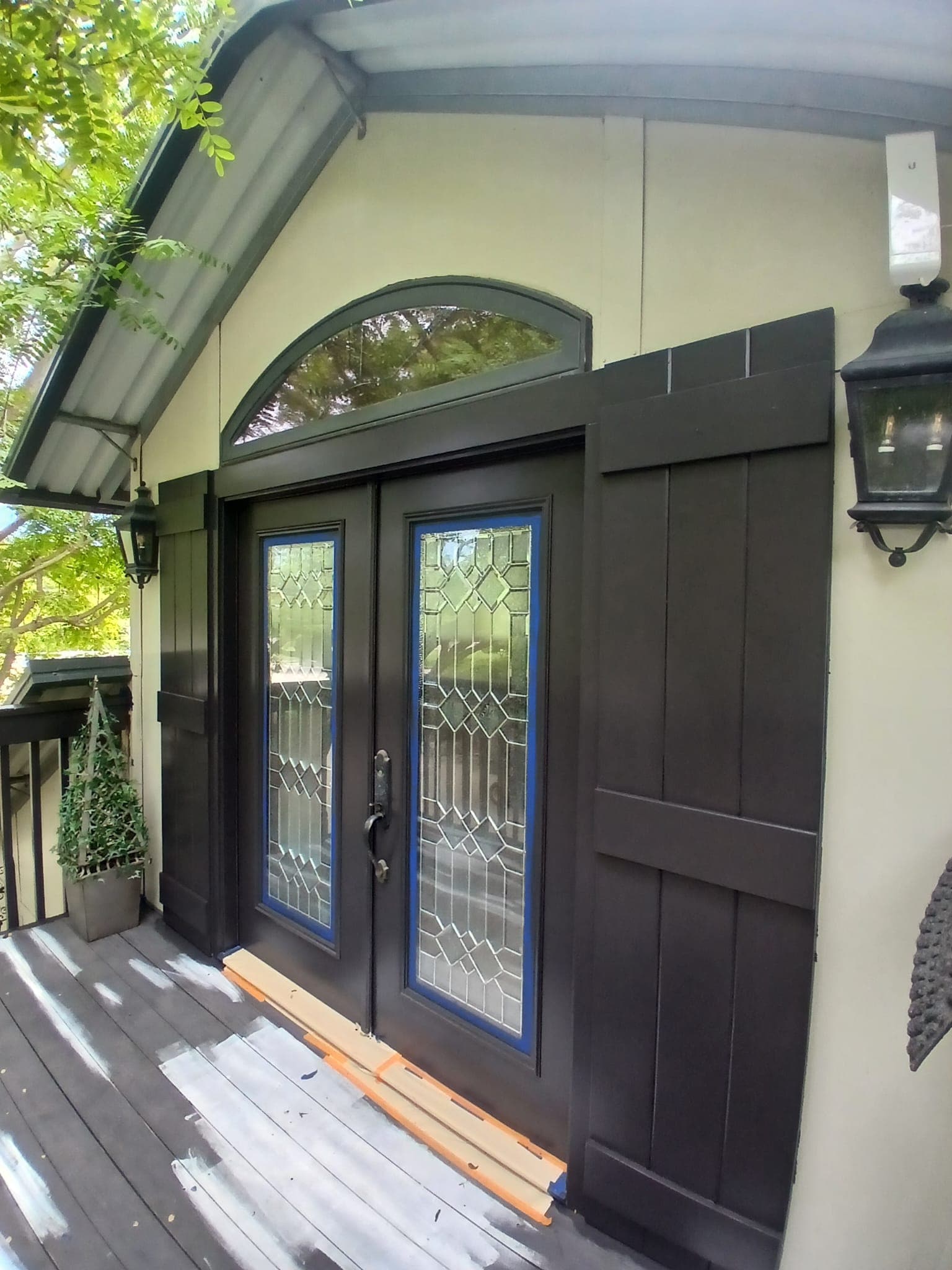 Exterior entry door masked and painted in a dark finish